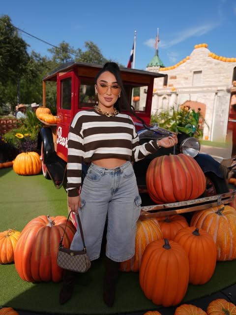 Guest posing with pumpkins beside the vintage red truck