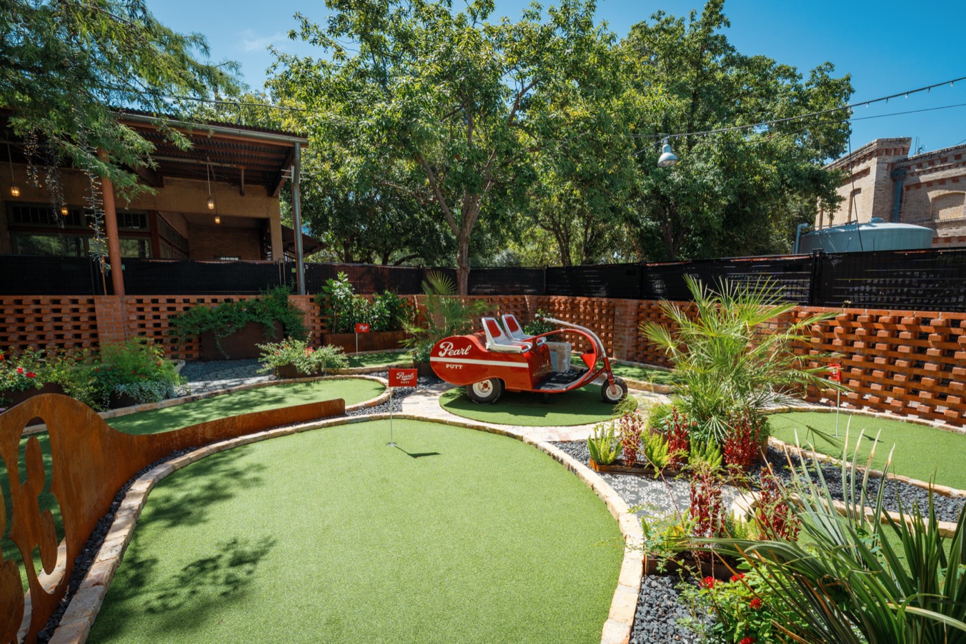 Open-air pavilion beside the course with putting greens in the foreground