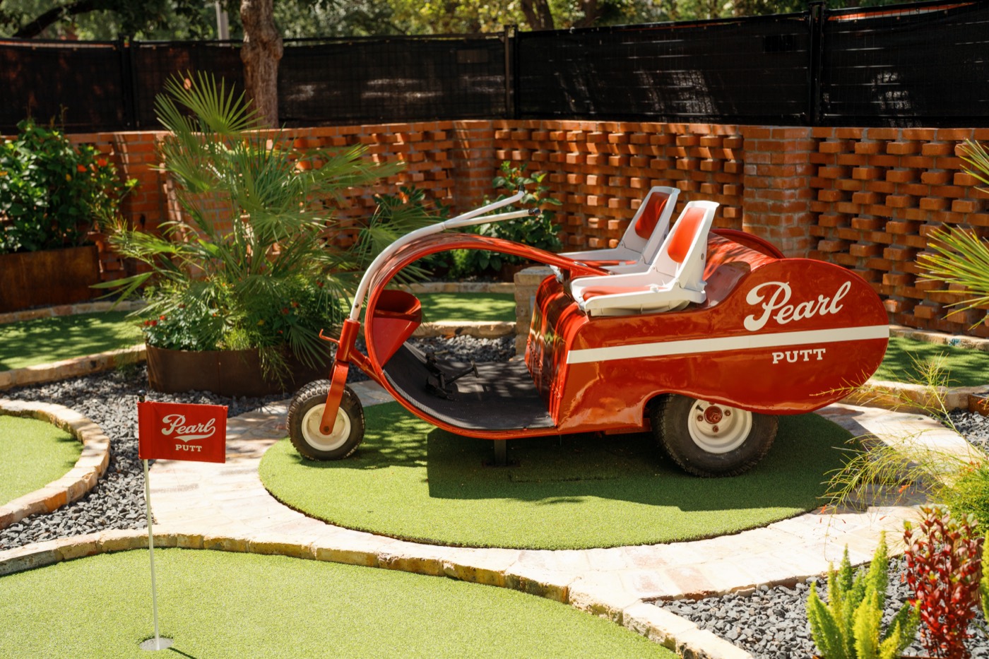 Vintage red Pearl car parked on the putting green